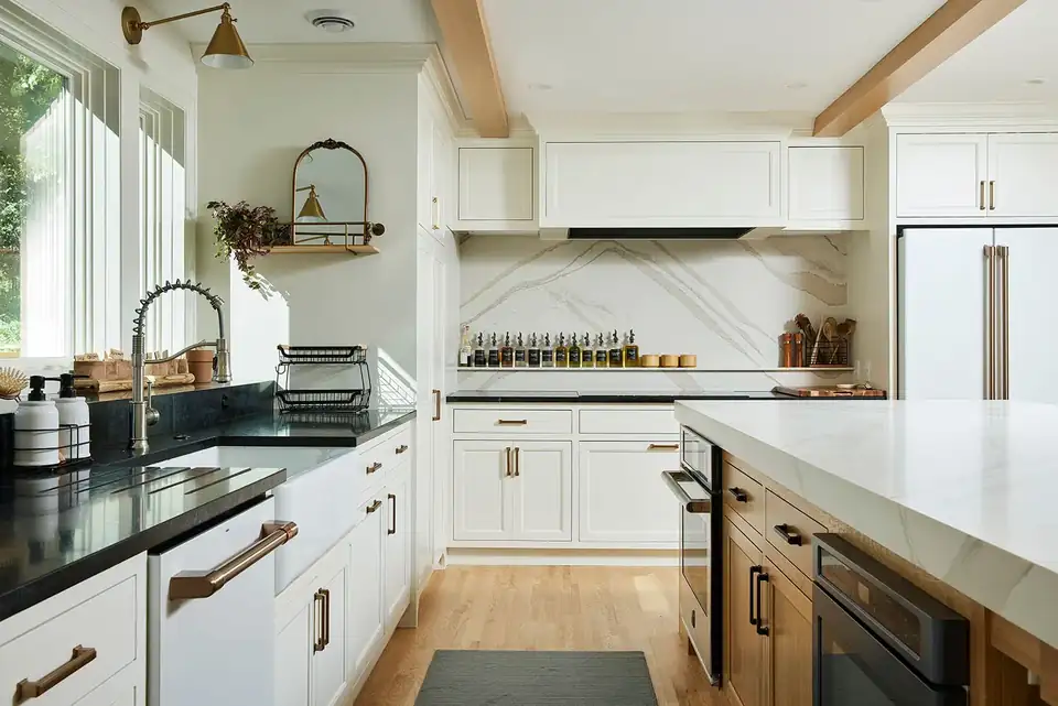 Kitchen remodeling Minneapolis area project in St. Louis Park with a Cambria island, soapstone perimeter counters, white cabinetry and GE Cafe appliances with champagne bronze handles