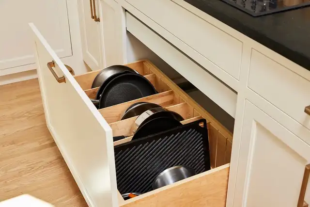 Custom kitchen drawer with wood pan dividers holding skillets and baking sheets, in a St. Louis Park, Minnesota remodel