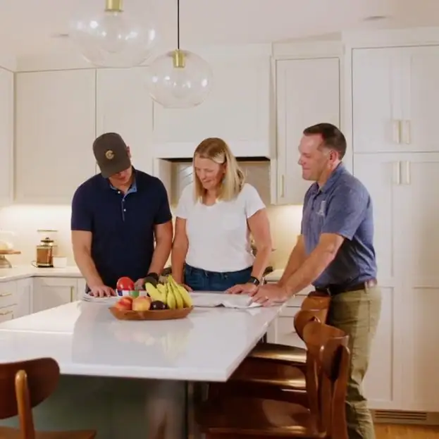 Sicora team members reviewing plans with a homeowner at a kitchen island